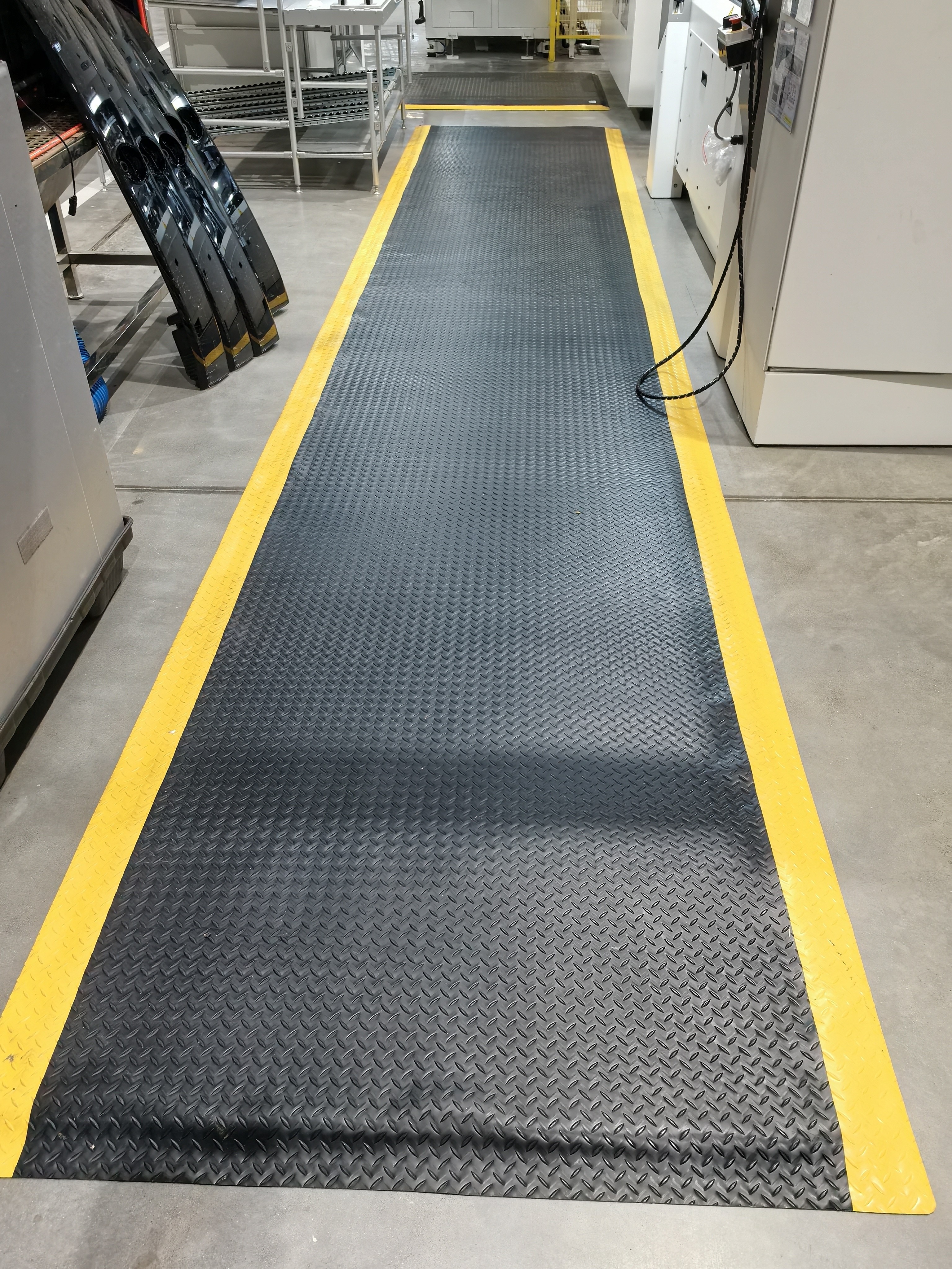Anti-fatigue mats along assembly line workstations