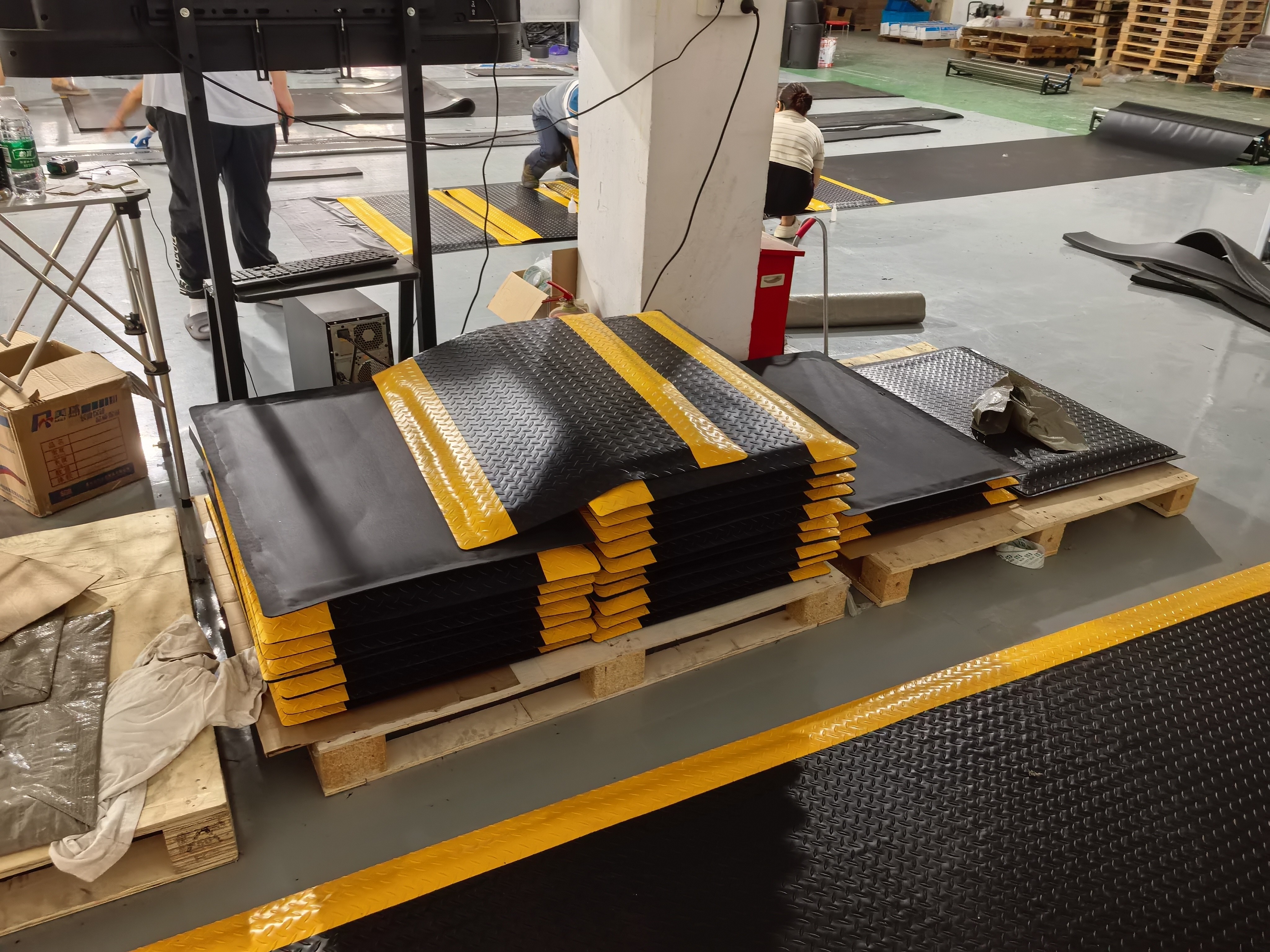 Anti-fatigue walkway mats in factory aisle